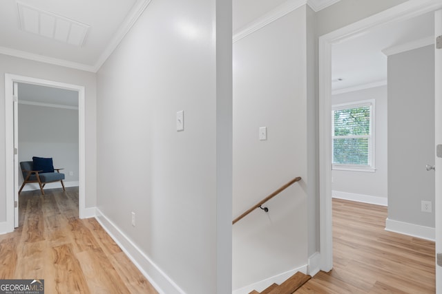 hall with light wood-type flooring and ornamental molding