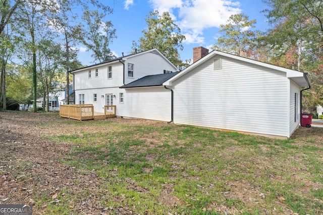 back of property with a wooden deck and a yard