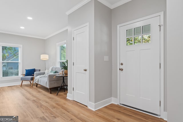 foyer featuring crown molding and light hardwood / wood-style flooring