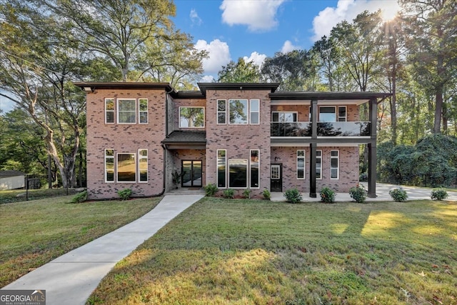 view of front of house featuring a balcony and a front yard