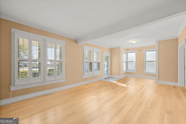 unfurnished living room with crown molding and light hardwood / wood-style flooring