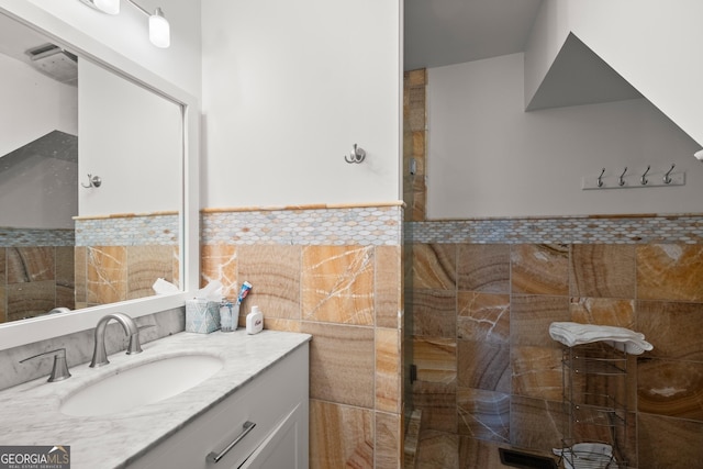 bathroom with vanity and tile walls