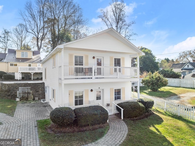 view of front of property with a balcony and a front lawn