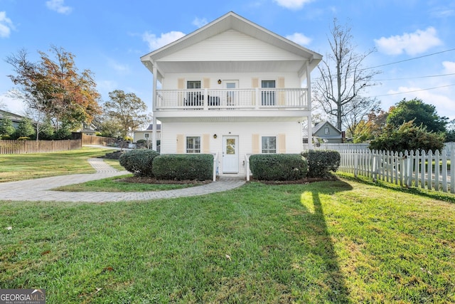 view of front facade with a balcony and a front lawn