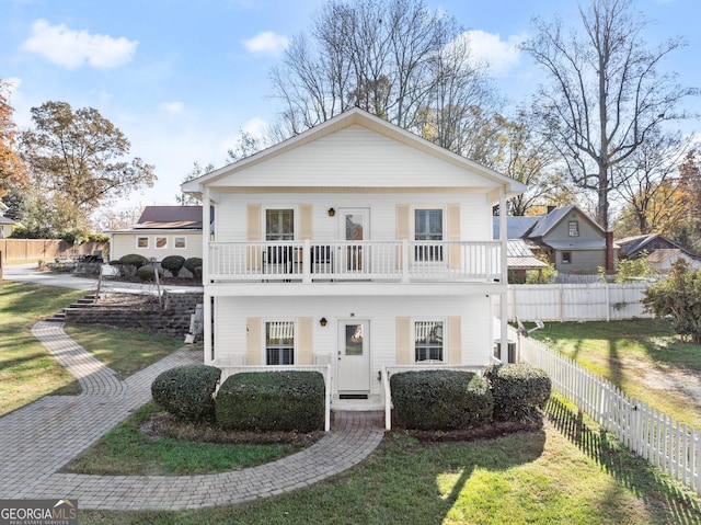 view of front of home featuring a front yard and a balcony