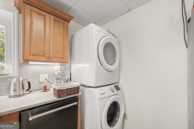 clothes washing area featuring stacked washing maching and dryer