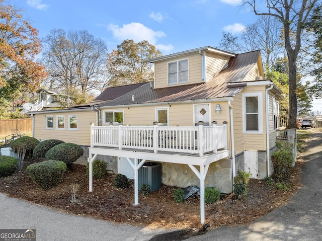 view of front of house with a wooden deck and cooling unit