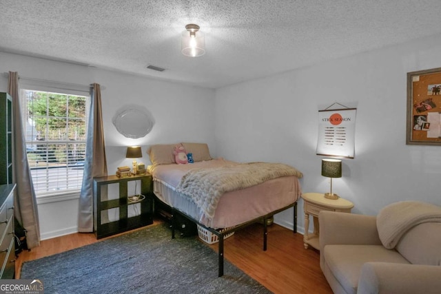 bedroom with wood-type flooring and a textured ceiling