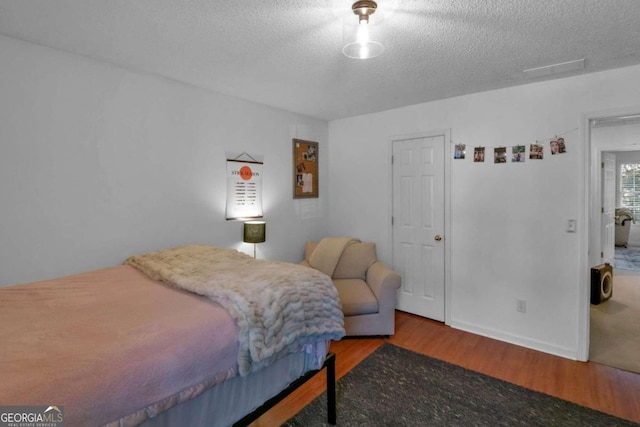 bedroom featuring hardwood / wood-style floors and a textured ceiling