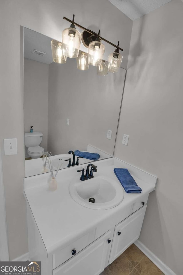 bathroom featuring tile patterned floors, vanity, toilet, and a textured ceiling