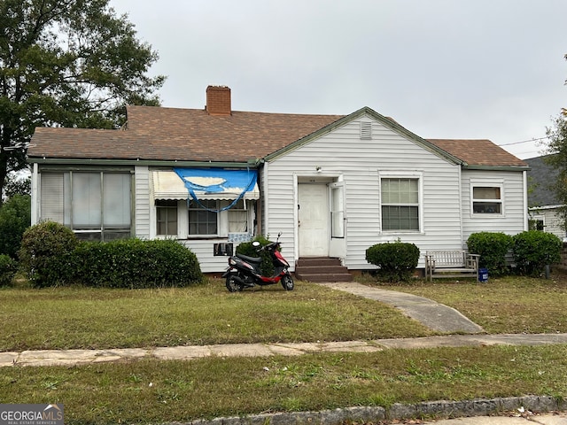 bungalow-style home with a front lawn