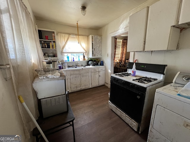 kitchen featuring washer / clothes dryer, a sink, dark wood-type flooring, light countertops, and gas range oven