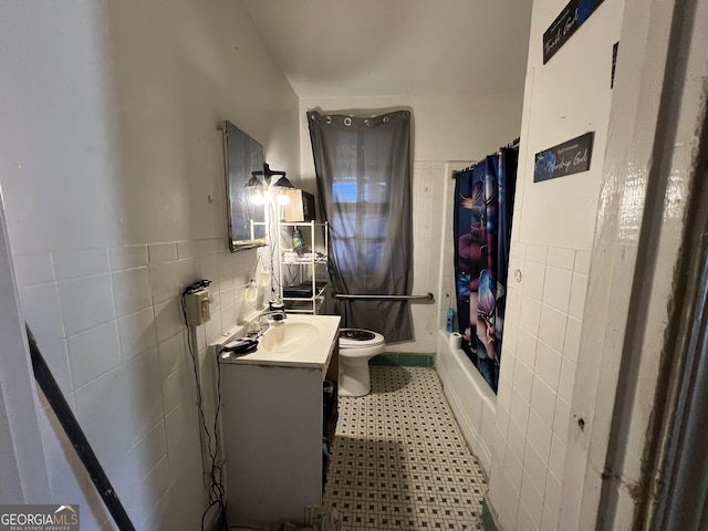 full bath featuring vanity, tile walls, toilet, and a wainscoted wall