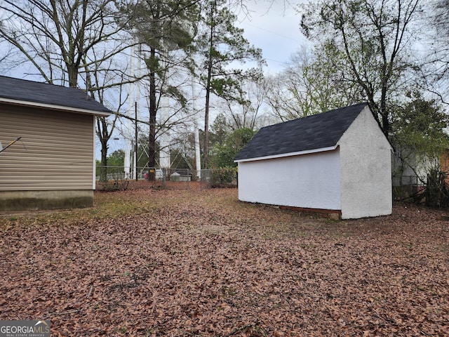 view of yard with an outbuilding, a storage shed, and fence