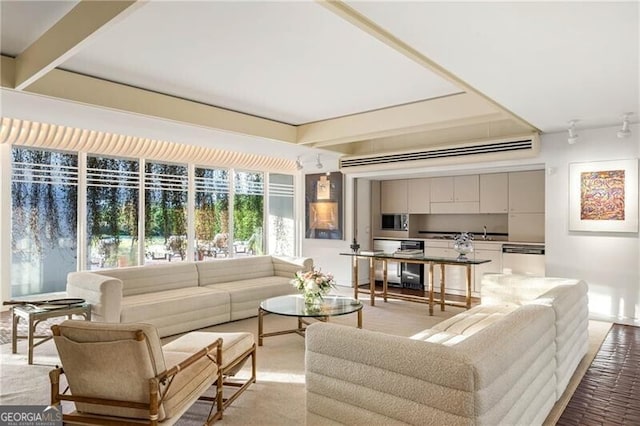 living room featuring beam ceiling and sink