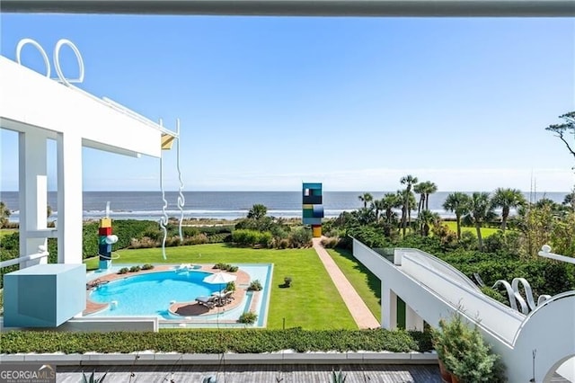 view of pool featuring a lawn and a water view