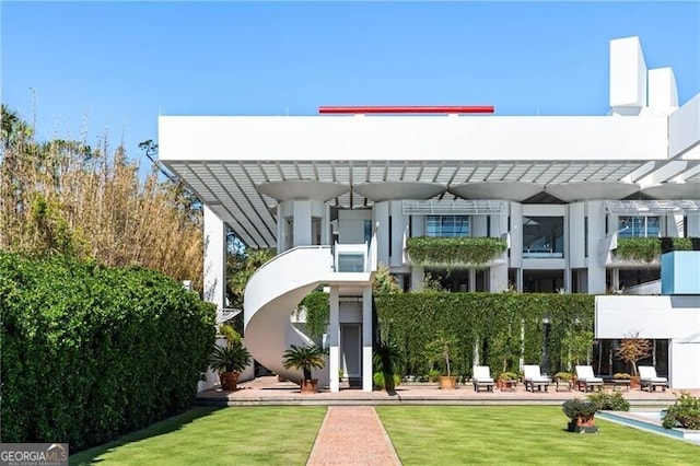 exterior space with a front yard, a patio, ceiling fan, and a pergola