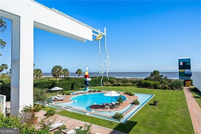 view of pool featuring a lawn and a water view