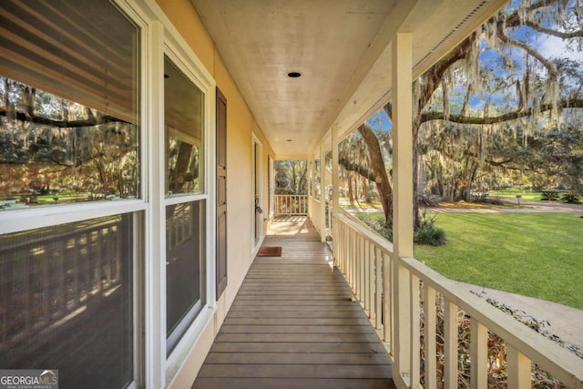 deck with covered porch and a yard