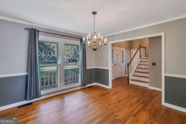 unfurnished dining area with an inviting chandelier, ornamental molding, and hardwood / wood-style flooring