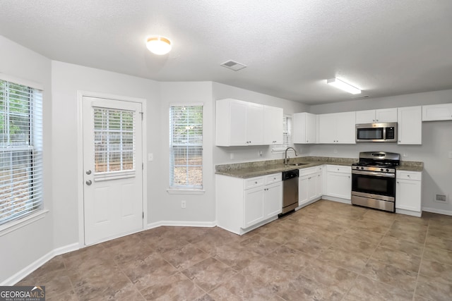 kitchen featuring white cabinets, plenty of natural light, sink, and stainless steel appliances