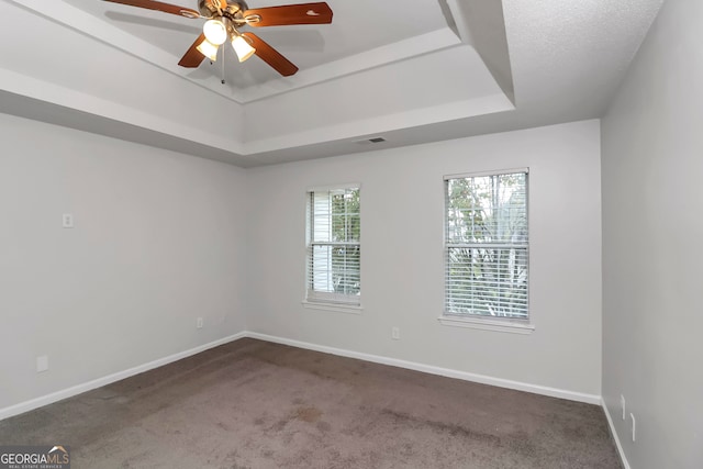 unfurnished room with carpet flooring, ceiling fan, and a tray ceiling