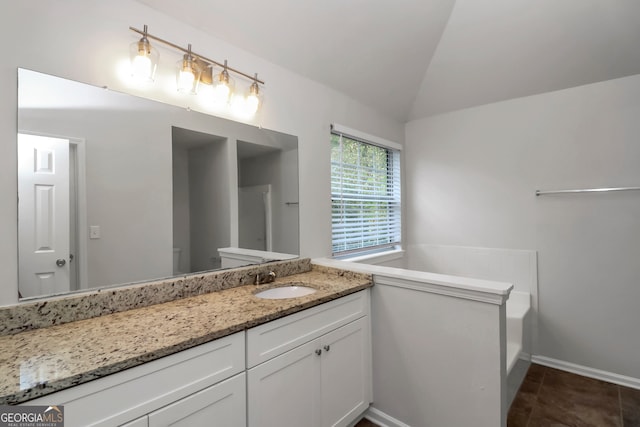 bathroom with tile patterned flooring, vanity, lofted ceiling, and toilet