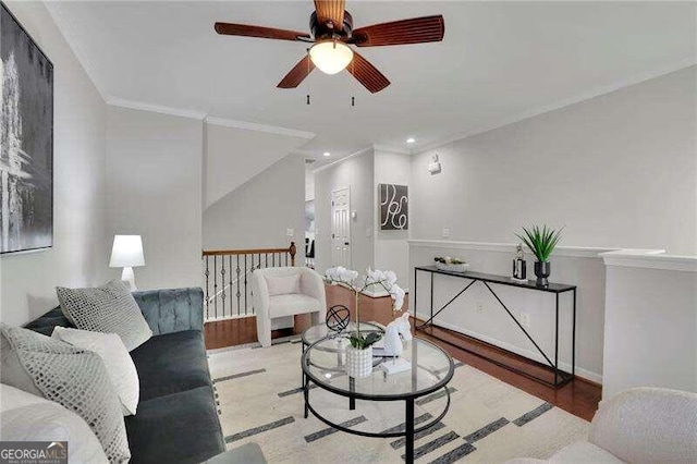 living room featuring ceiling fan, light wood-type flooring, and crown molding