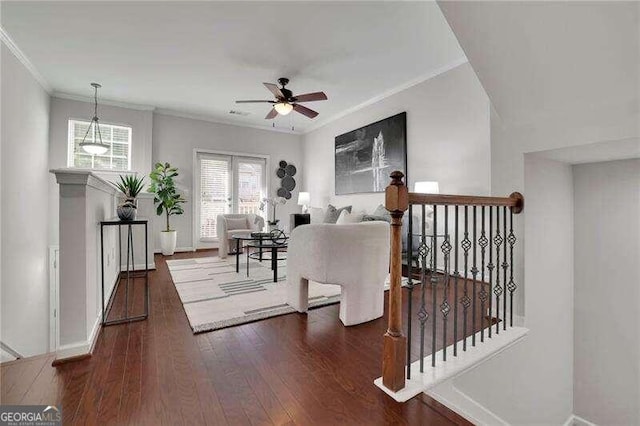 living room featuring dark hardwood / wood-style floors, ceiling fan, and crown molding