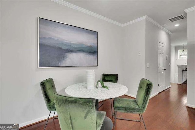 dining space featuring crown molding and dark wood-type flooring