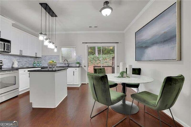 kitchen with a center island, white cabinets, decorative light fixtures, dark hardwood / wood-style flooring, and stainless steel appliances