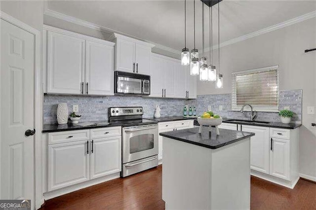 kitchen featuring white cabinets, a kitchen island, sink, and appliances with stainless steel finishes