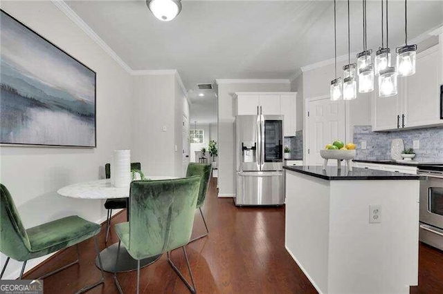 kitchen featuring decorative light fixtures, dark hardwood / wood-style flooring, white cabinetry, and appliances with stainless steel finishes