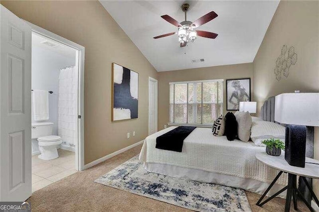 bedroom with connected bathroom, light colored carpet, ceiling fan, and lofted ceiling