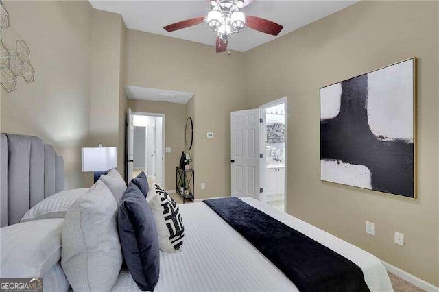 carpeted bedroom with ensuite bath and ceiling fan