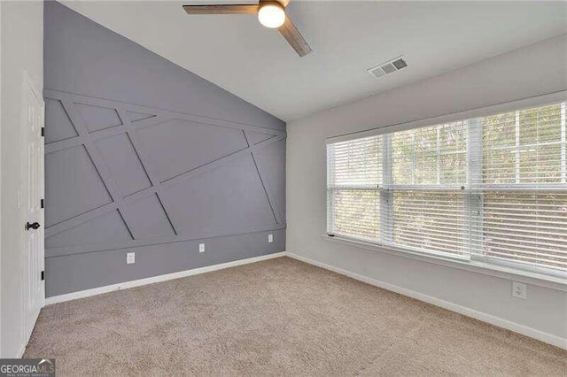 spare room featuring ceiling fan, light colored carpet, and lofted ceiling