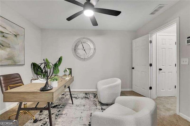 carpeted office featuring ceiling fan