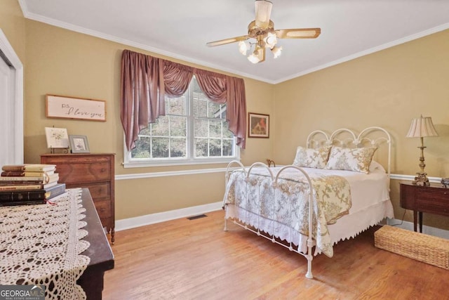 bedroom with light hardwood / wood-style flooring, ceiling fan, and crown molding