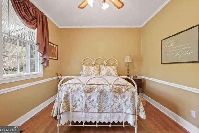 bedroom with hardwood / wood-style flooring, ceiling fan, and crown molding