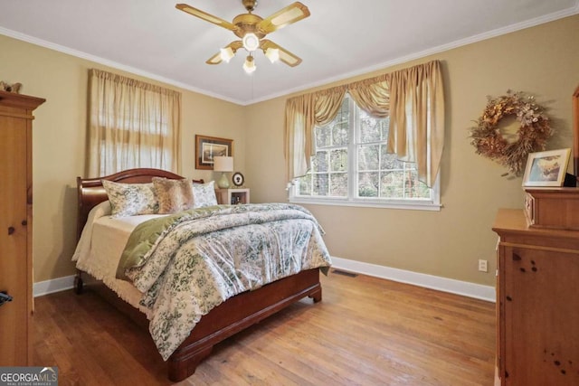 bedroom featuring wood-type flooring, ceiling fan, and crown molding