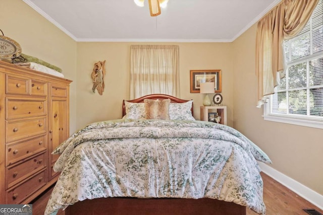 bedroom featuring wood-type flooring, ceiling fan, and ornamental molding