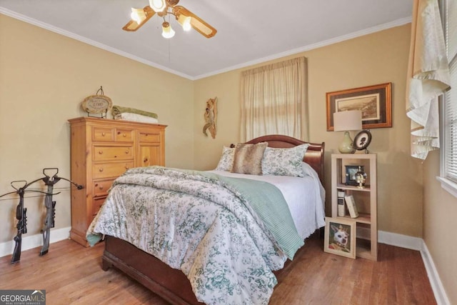 bedroom with multiple windows, hardwood / wood-style floors, ceiling fan, and ornamental molding