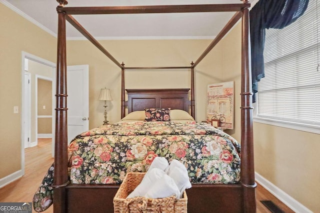 bedroom with wood-type flooring and crown molding