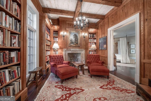 sitting room with an inviting chandelier, wooden walls, hardwood / wood-style flooring, built in features, and beam ceiling