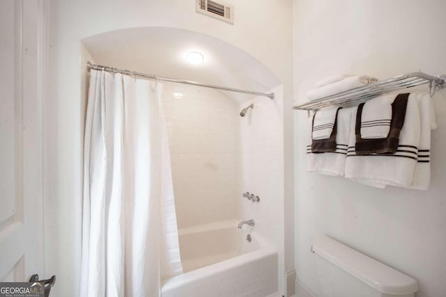 bathroom featuring shower / bath combo with shower curtain and toilet