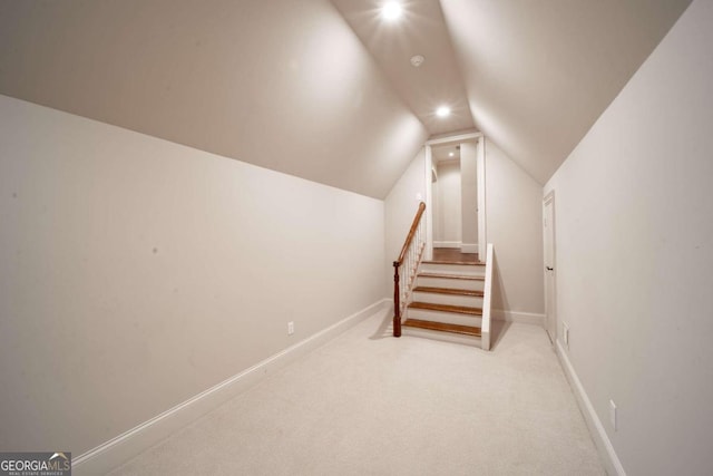 stairway with carpet floors and lofted ceiling