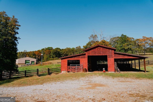 view of horse barn with a rural view