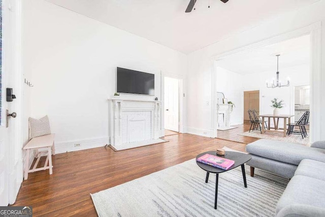 living room featuring ceiling fan with notable chandelier and wood-type flooring