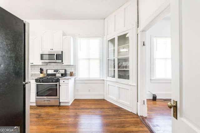 kitchen featuring backsplash, dark wood-type flooring, white cabinetry, and appliances with stainless steel finishes