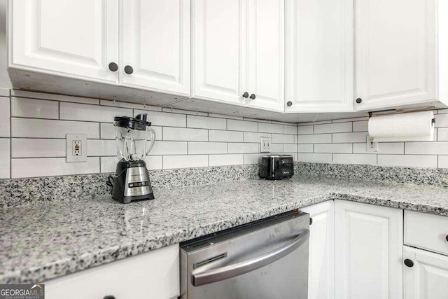 kitchen featuring backsplash, dishwasher, light stone counters, and white cabinetry